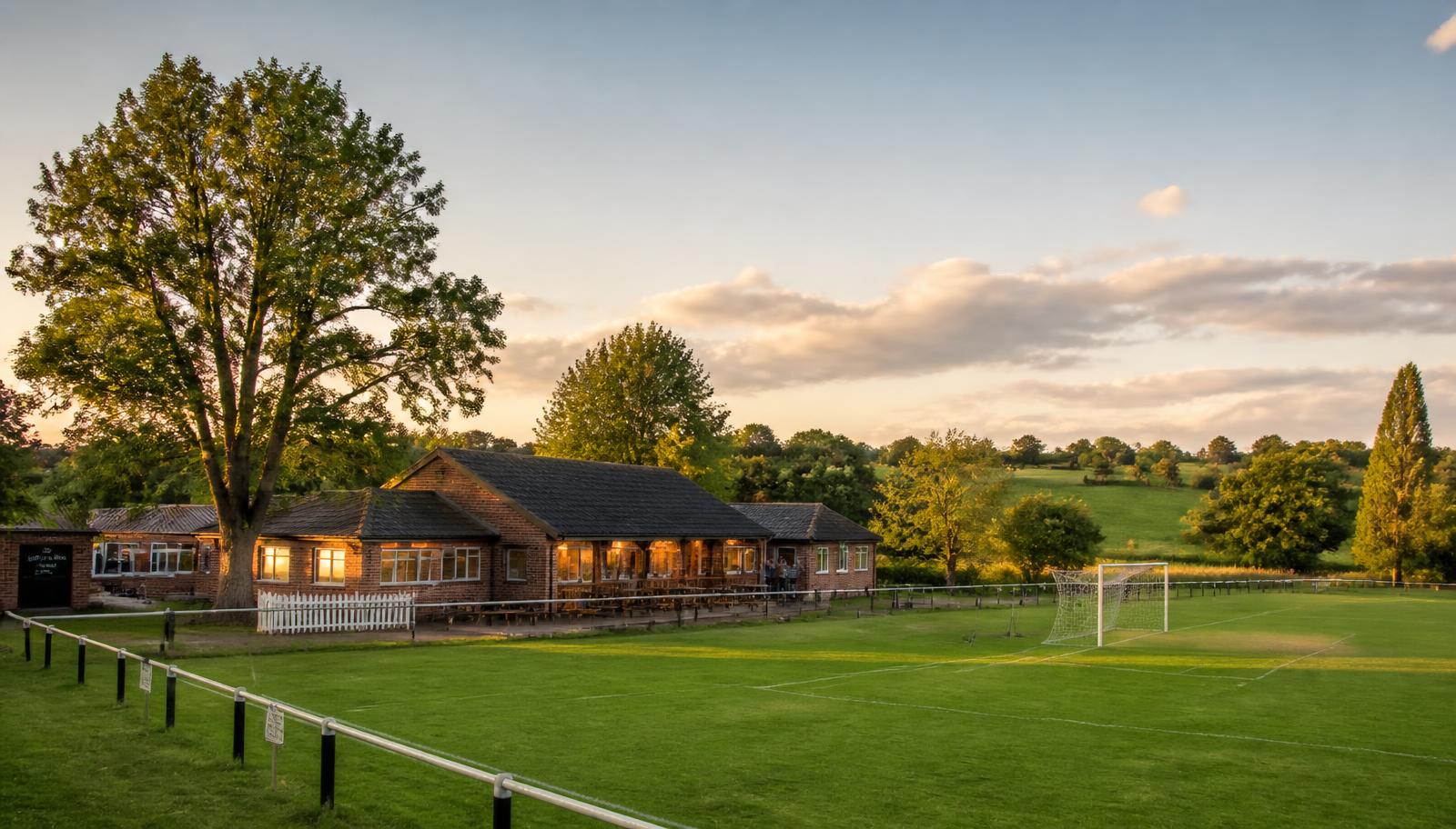 Clubhouse and football pitches at North Kilworth Sports Club in evening sunlight